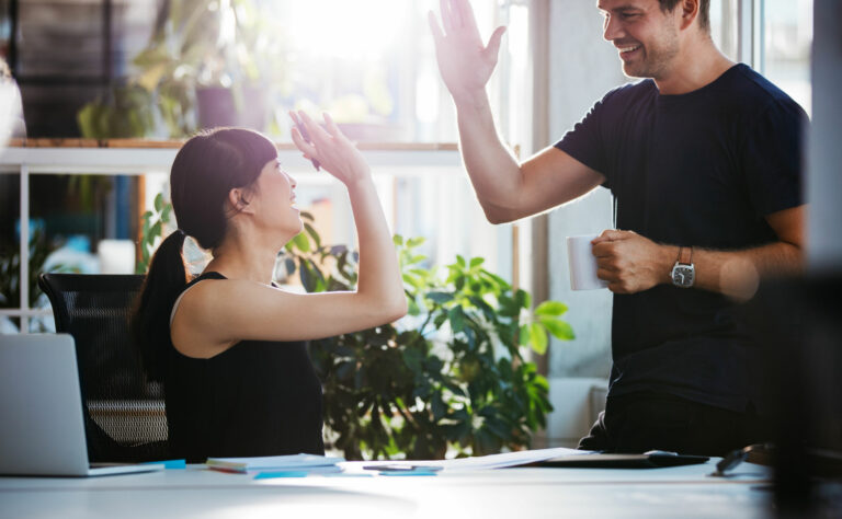 Une femme et un homme se tapant dans la main pour montrer leur accord en signe d'efficacité professionnelle